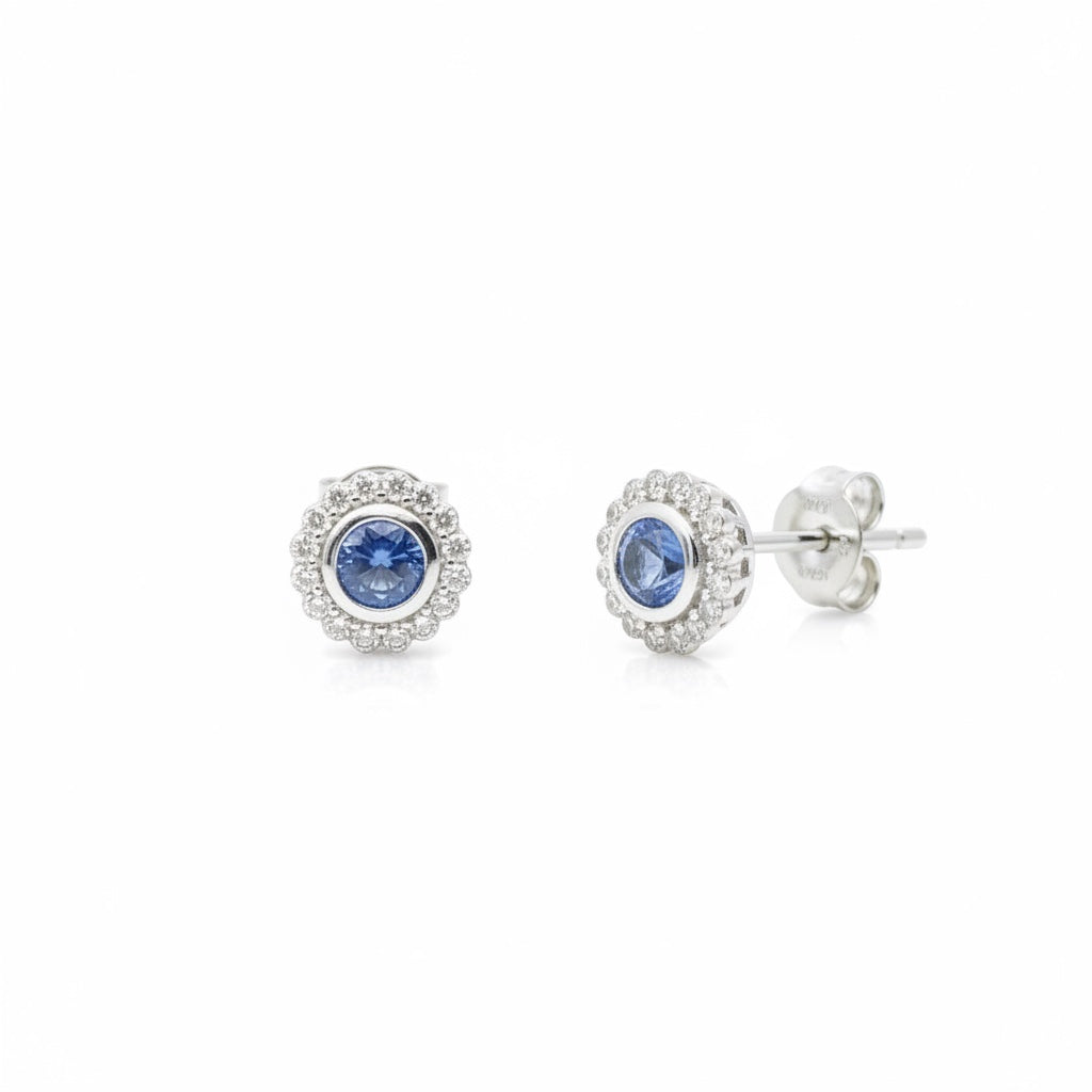 Maison Leininger 18K white gold stud earrings with round blue sapphires surrounded by small diamonds.